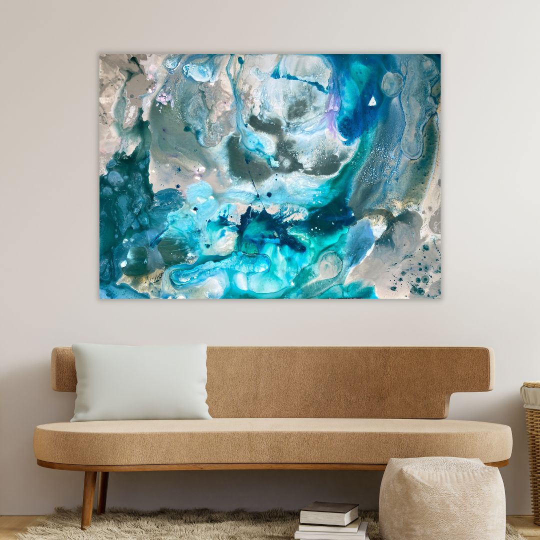 Abstraktmaler i blå nuancer hænger på en væg over en sandfarvet sofa